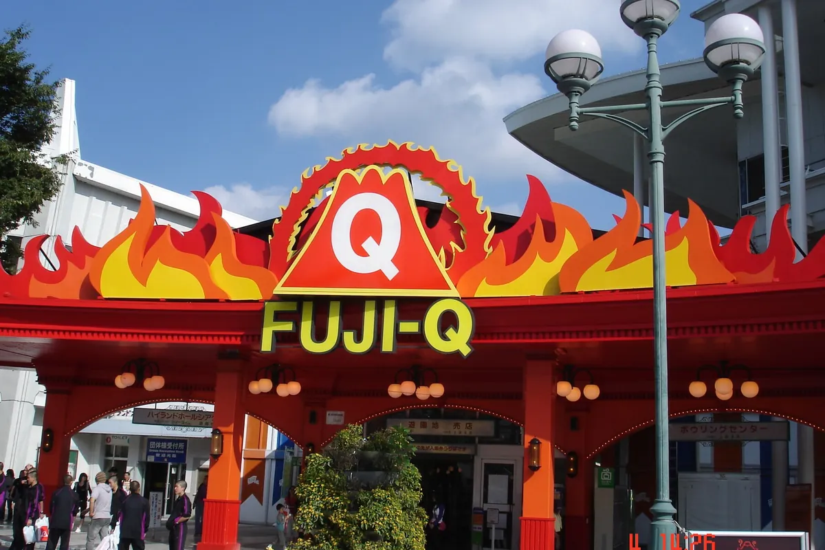 「FUJI-Q」と書かれた炎のデザインの看板が掲げられた富士急ハイランドの入口の写真