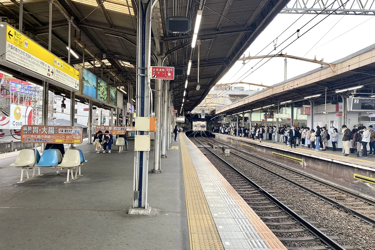 近鉄八尾駅のホームで電車を待つ利用者が多数並んでいる様子の写真