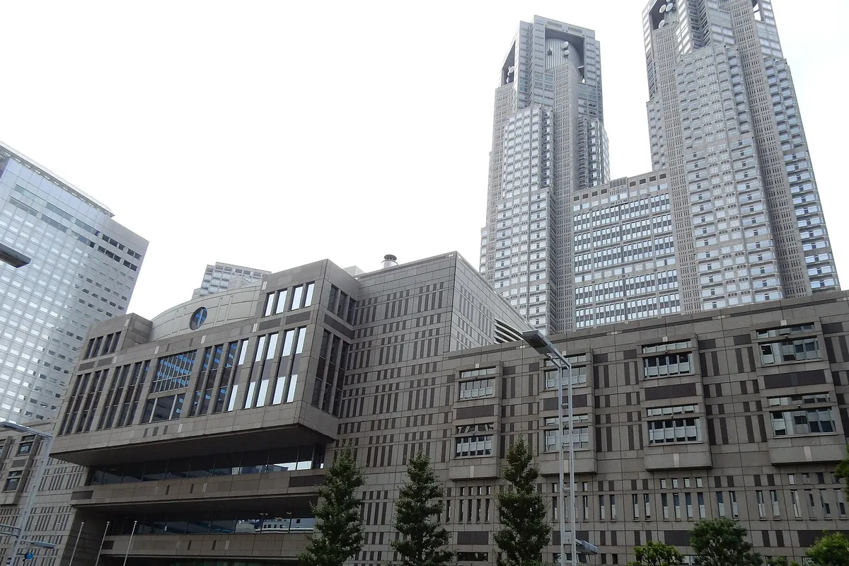 低層の庁舎棟と背後にそびえる双塔のビルからなる建物の外観の写真