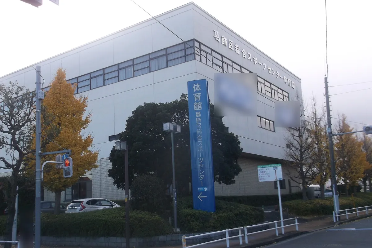 葛飾区総合スポーツセンター体育館の建物外観と「体育館」と書かれた青い案内看板の写真