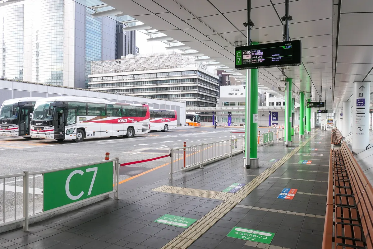 バスタ新宿のバス乗り場で、京王ハイウェイエクスプレスの高速バス車両が「C7」乗り場に並んで停車している様子の写真
