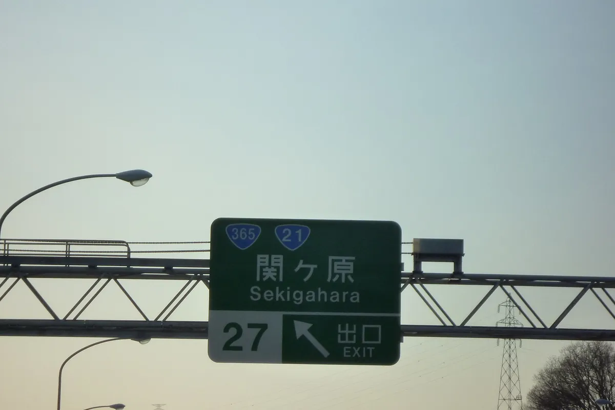 高速道路の標識柱に「関ヶ原 Sekigahara」27番出口を示す緑色の案内標識が矢印とともに設置されている写真