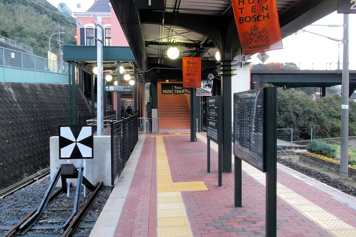 ハウステンボス駅のホームで「HUIS TEN BOSCH」の幕や案内板が並ぶ様子の写真