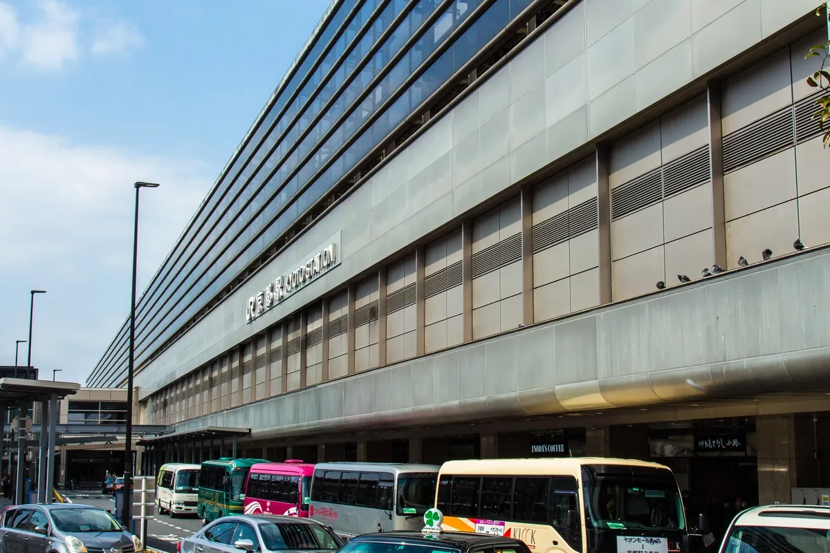 京都駅ビルの外観で、「KYOTO STATION」の看板がある建物の前にバスやタクシーが並ぶ様子の写真