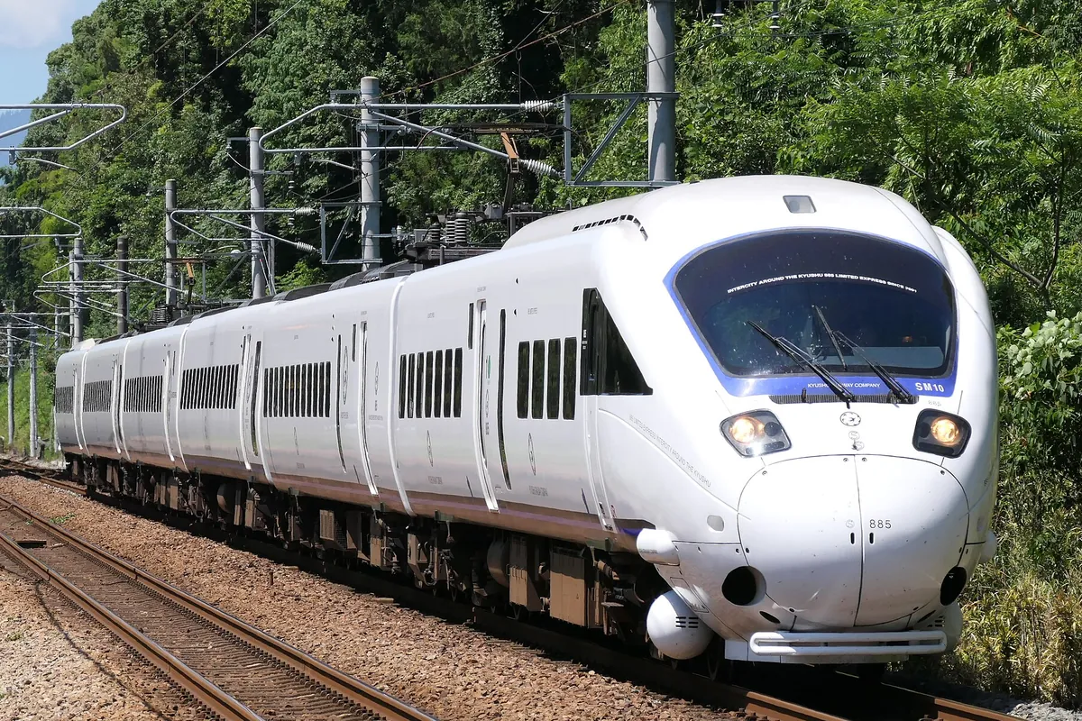 森の中の線路を走るJR九州885系特急電車の先頭部を正面から写した写真