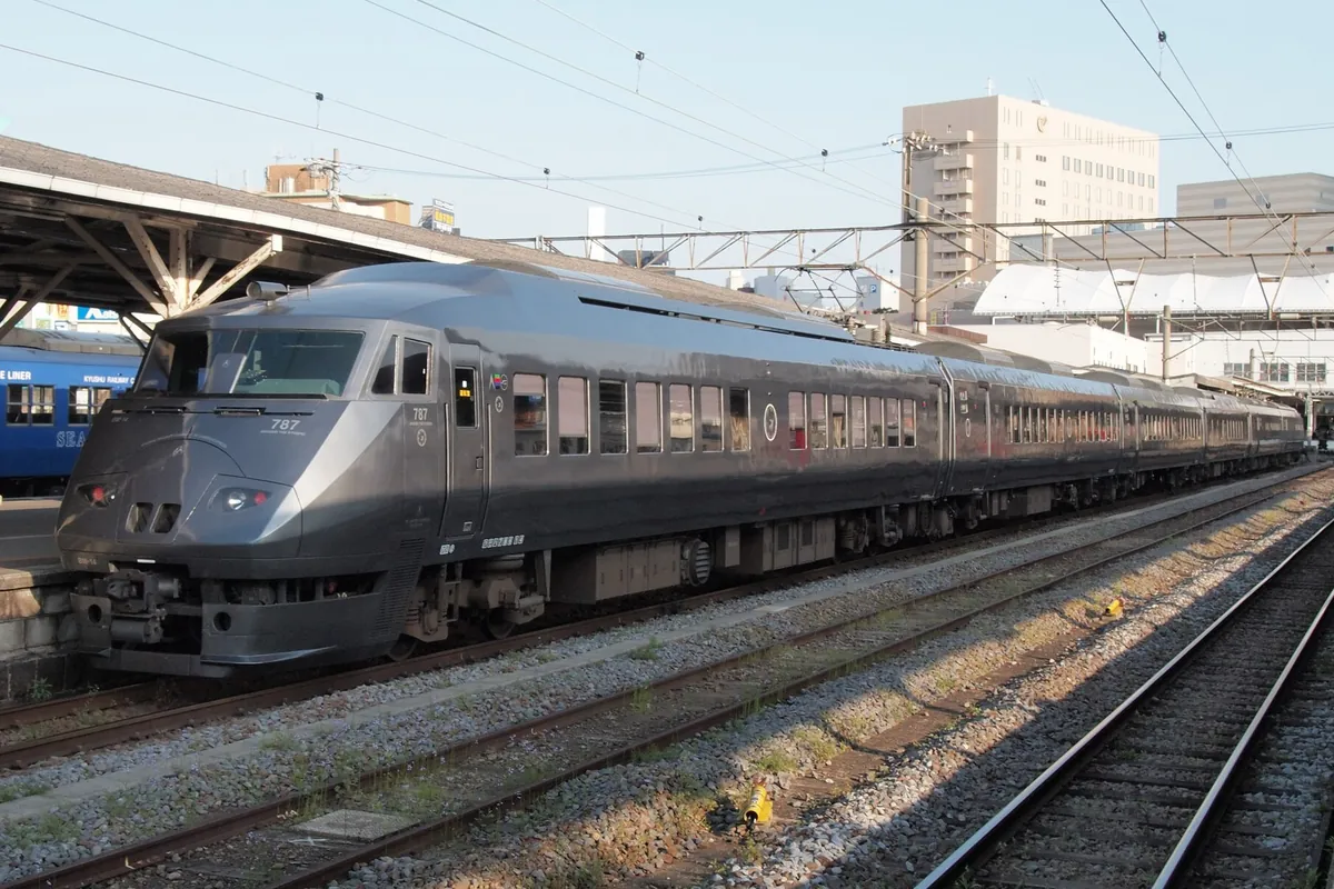 駅のホームに停車するJR九州787系特急電車の先頭車両を側面から写した写真