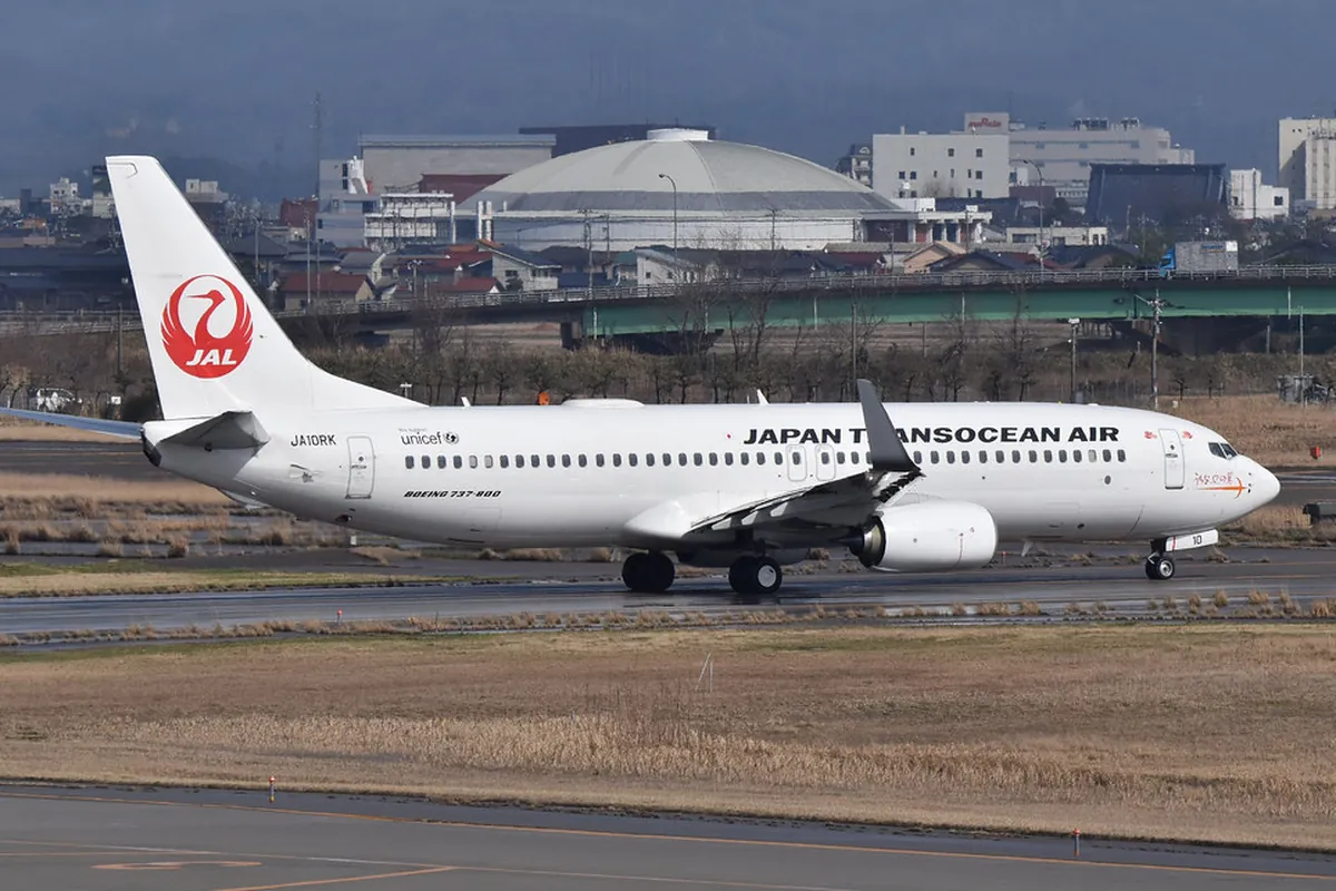 日本トランスオーシャン航空の「JAPAN TRANSOCEAN AIR」とJALロゴの入ったボーイング737-800機が空港の誘導路を走行する様子の写真