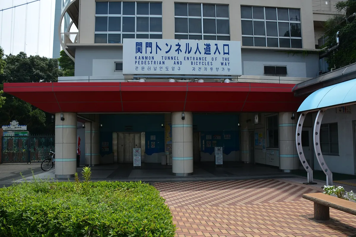 「関門トンネル人道入口」と書かれた看板がある赤い庇の建物入口の写真
