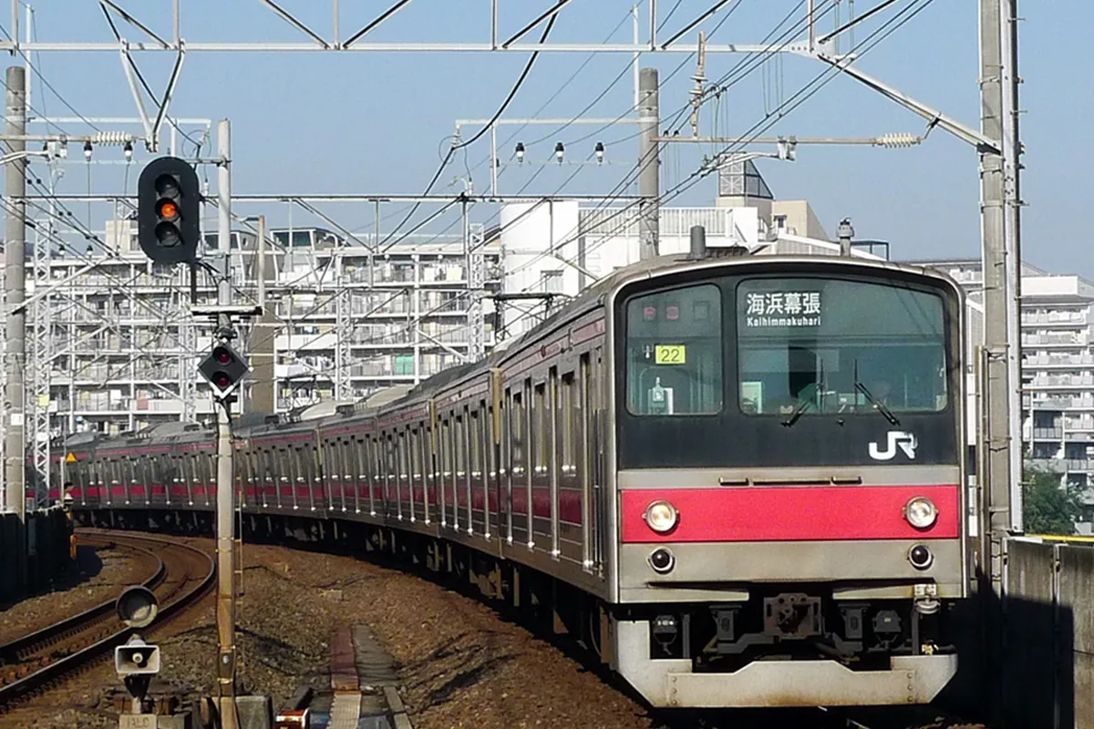 行き先表示に「海浜幕張」と出たJR京葉線の車両が線路のカーブを走行している様子の写真