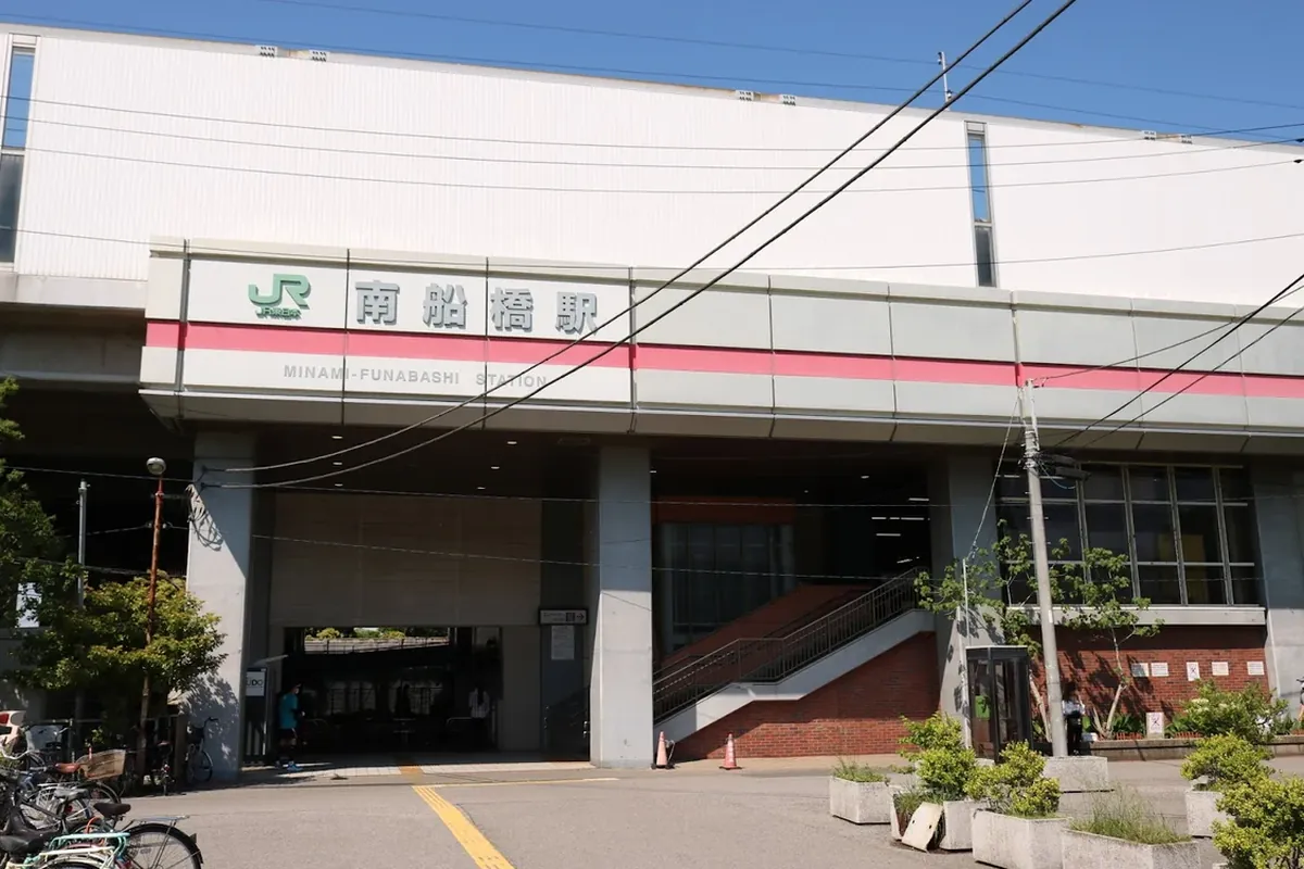 「南船橋駅」と大きく表示された駅舎の入口と、駅前に並ぶ自転車の様子の写真