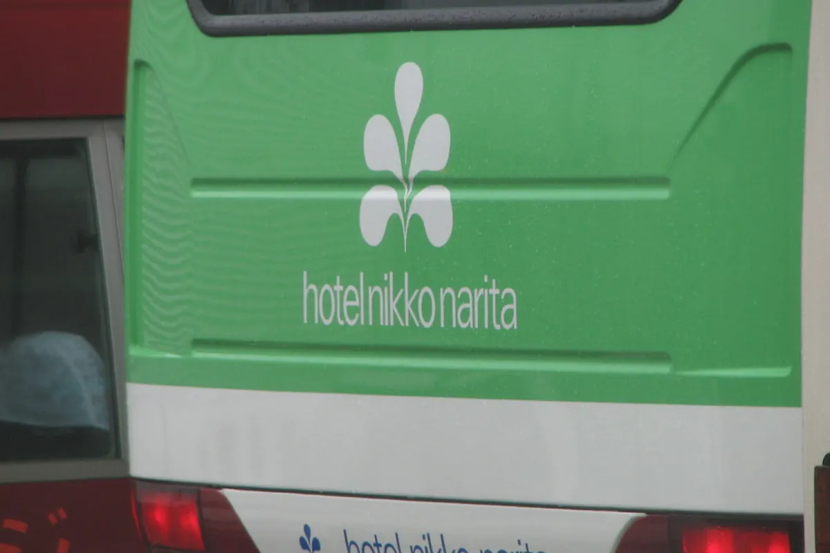 緑色のバスの後部に「hotel nikko narita」のロゴと文字が書かれている送迎バスの写真