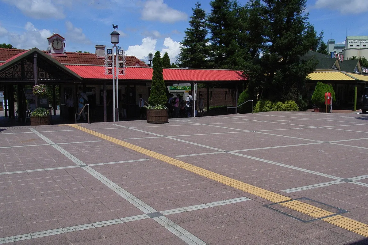 道の駅の広場で、赤や黄色の屋根の建物と時計塔、整備された石畳の通路が並ぶ様子の写真
