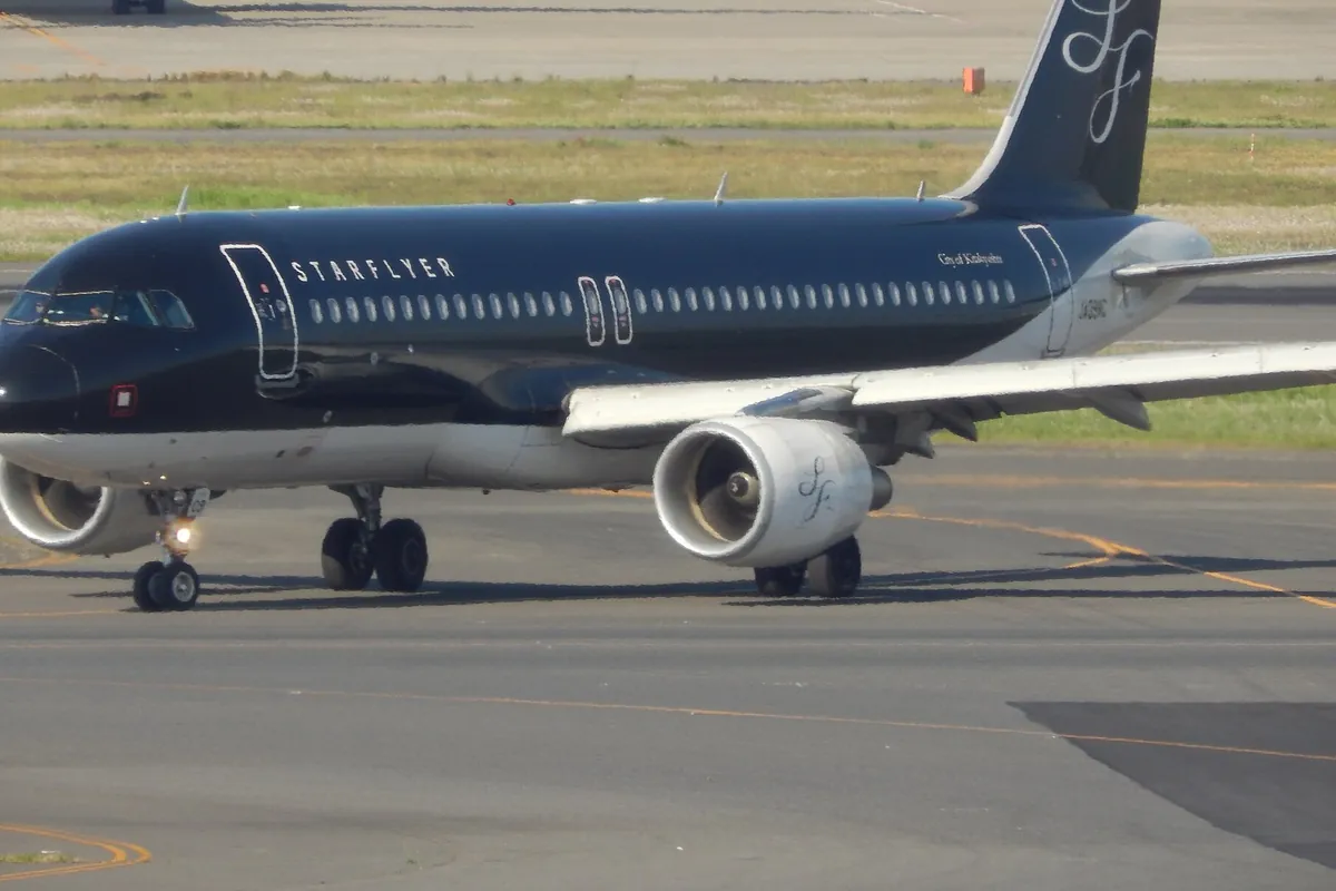空港の誘導路で「STARFLYER」と書かれた黒い機体のエアバス機が走行する様子の写真