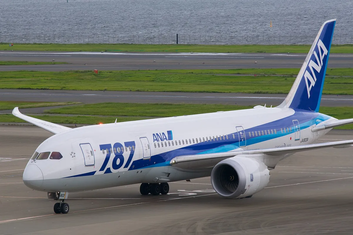 空港の誘導路でANAの「787」と書かれたボーイング787型機が駐機場に向けて走行している写真