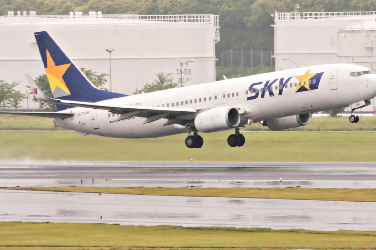 空港の滑走路から離陸するスカイマークの旅客機を横から捉えた写真