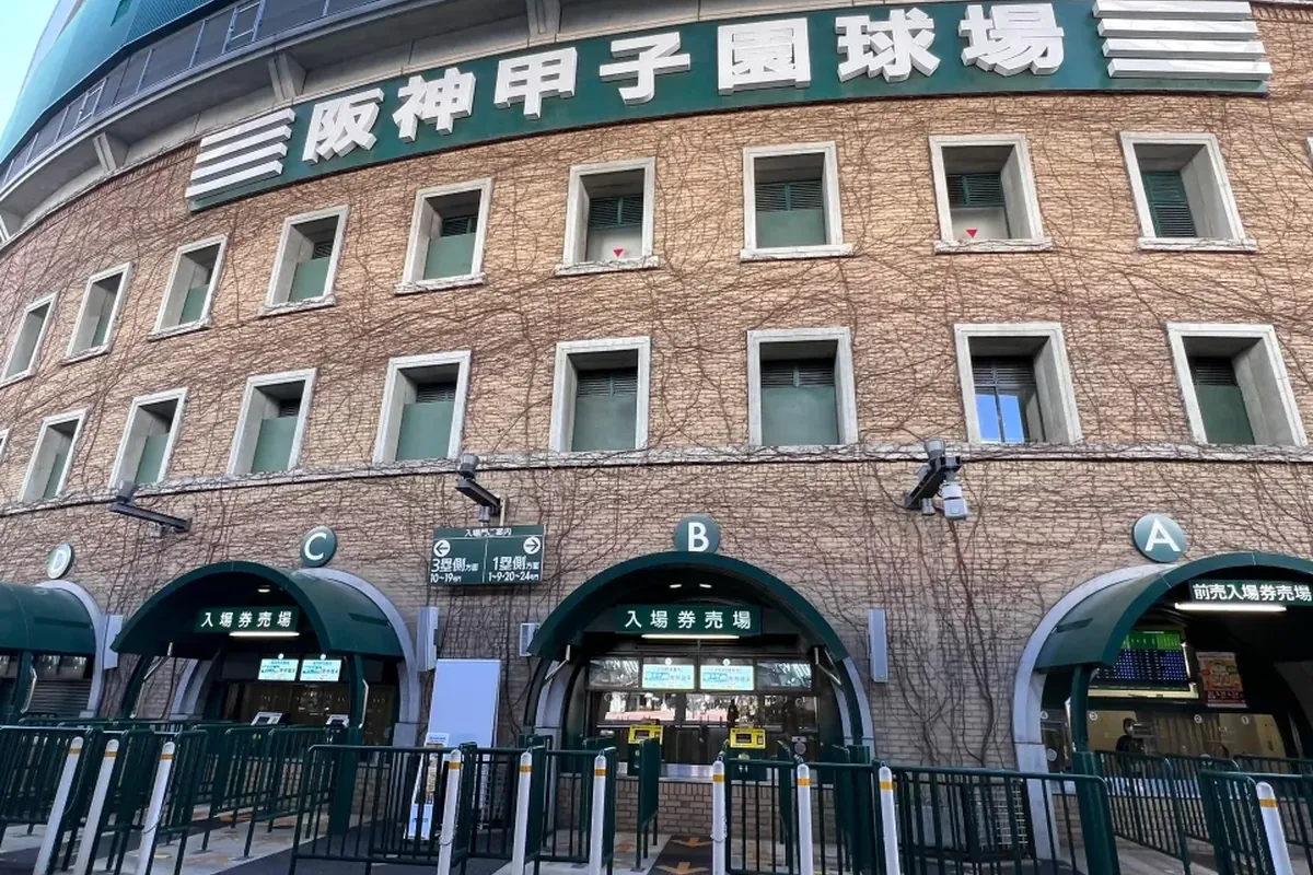 阪神甲子園球場の入場ゲート付近で「阪神甲子園球場」の看板と入場券売場、A・B・Cの入り口案内が写る写真