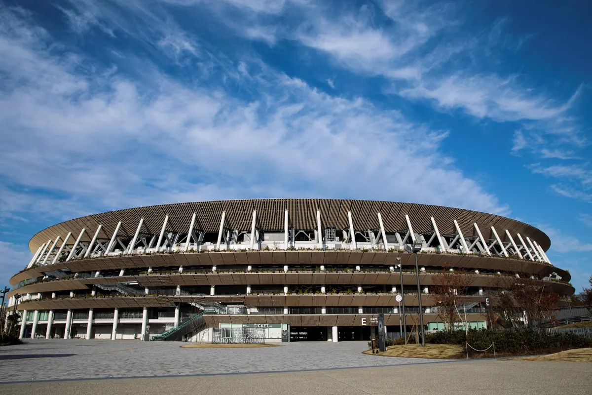 国立競技場の外観で、木目調のひさしと白い柱が並ぶ円形の建物全体が写る写真