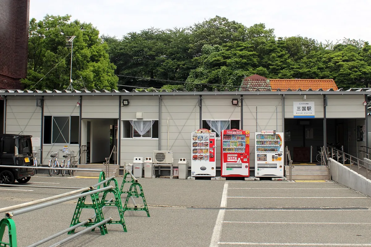 「三国駅 MIKUNI STATION」の看板がある駅舎前に自動販売機が並ぶ様子の写真