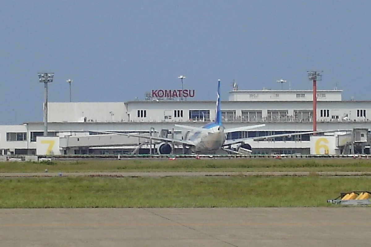 「KOMATSU」の表示があるターミナルビルの前に旅客機が駐機している小松空港の写真