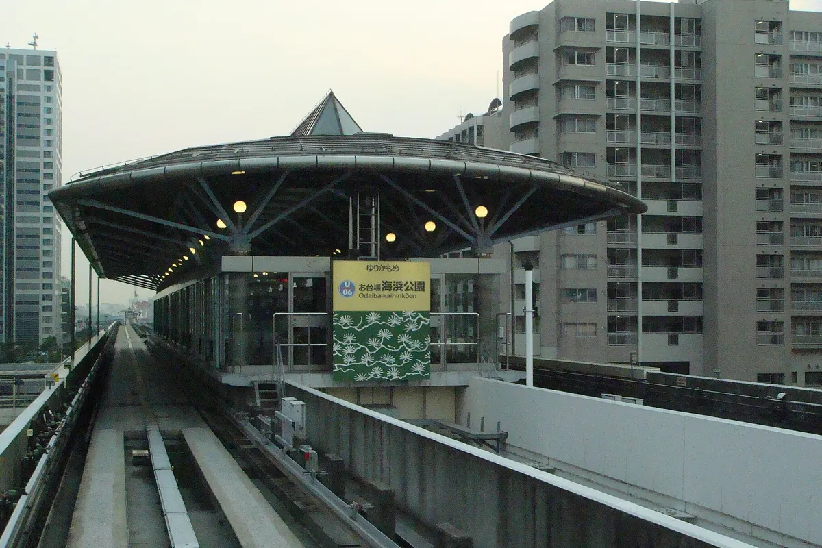 ゆりかもめ「お台場海浜公園」駅のホームで、円形の屋根と駅名サインが見える様子の写真