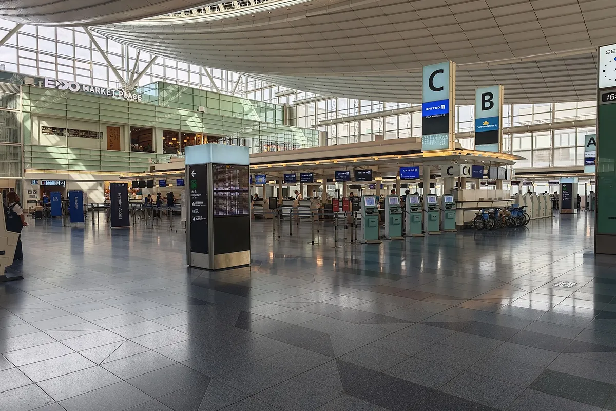 空港の出発ロビーでUNITEDやVietnam Airlinesのカウンターが並ぶ様子の写真
