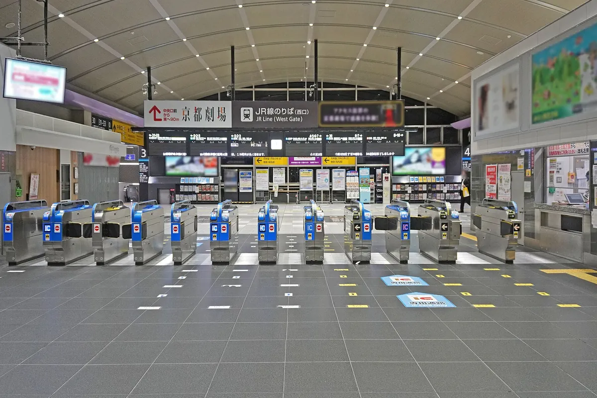 京都駅のJR線西口改札に自動改札機が並び「京都劇場」の案内看板が掲げられた様子の写真