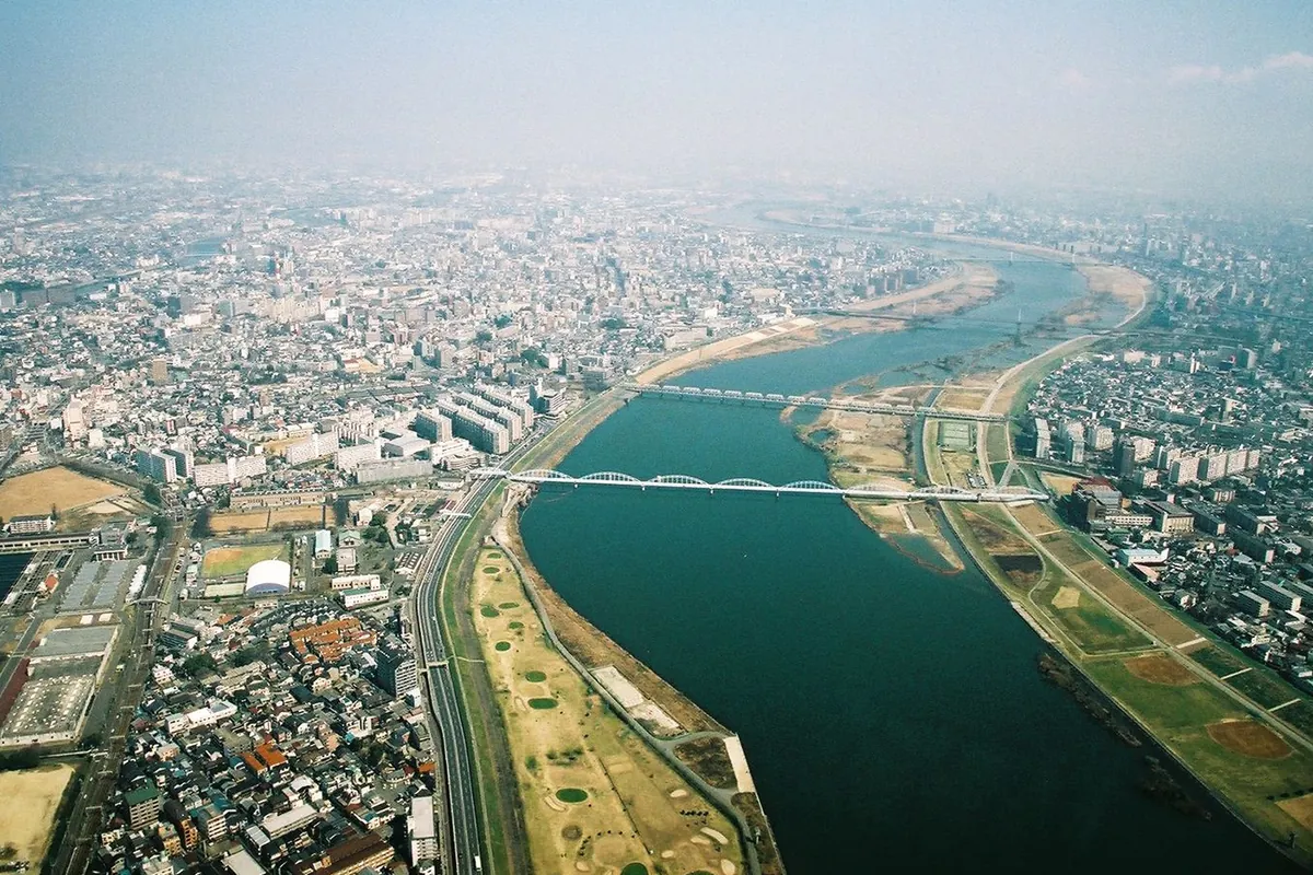 淀川の河川敷と橋、周辺の市街地を上空から見た様子の写真