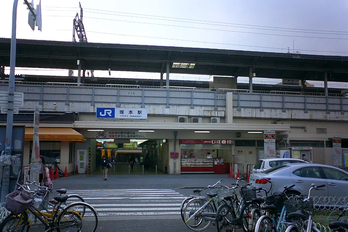 JR塚本駅の駅舎前で、改札に続く通路と自転車置き場、駅前のロータリーが写る写真