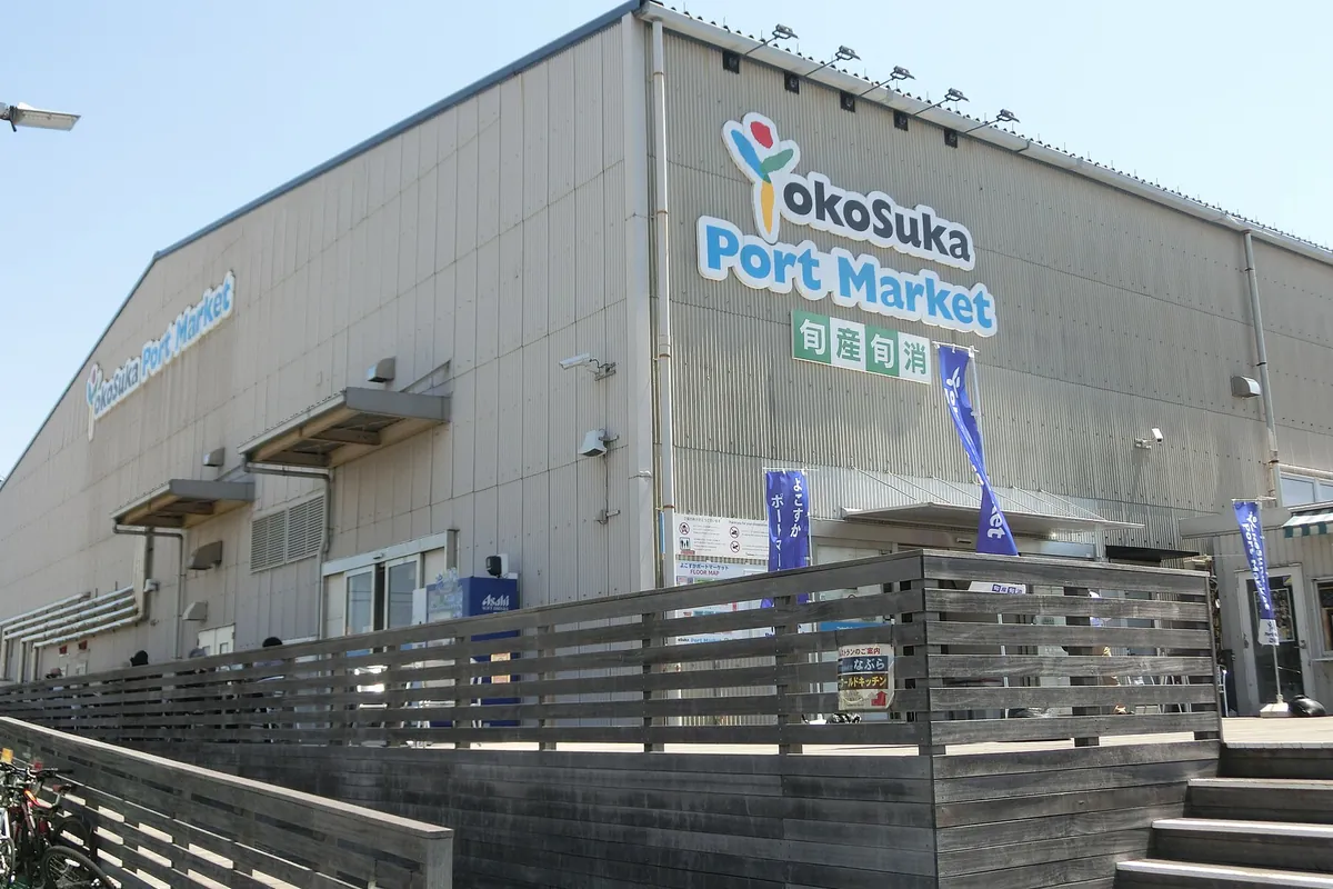 「YokoSuka Port Market」と書かれた建物の外壁に「旬産旬消」の看板とのぼり旗が立つ様子の写真