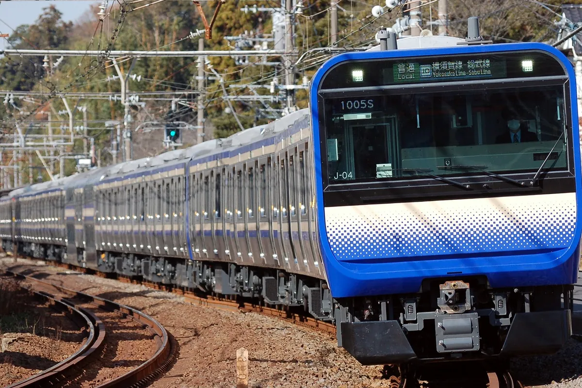 横須賀線E235系1000番台の車両が「普通 横須賀線 総武線」の表示を出して線路上を走行する様子の写真